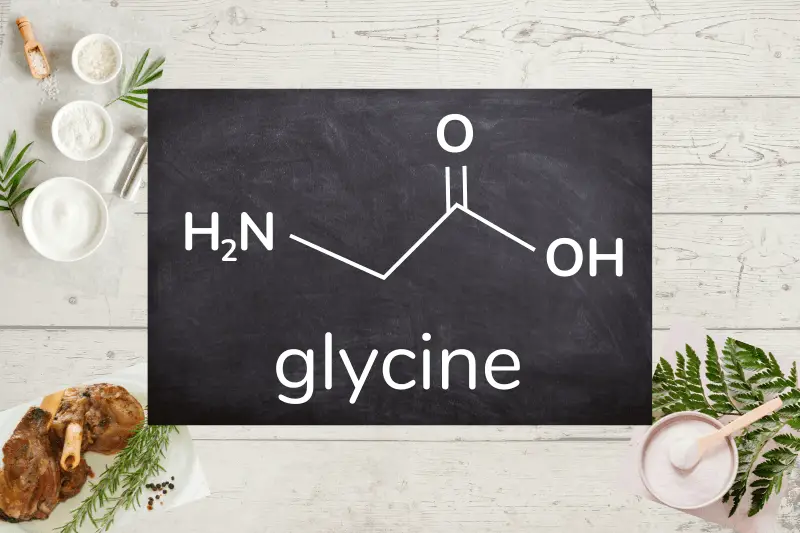 glycine chemical structure on a blackboard with collagen powders and collagen-rich meat on a light wood background