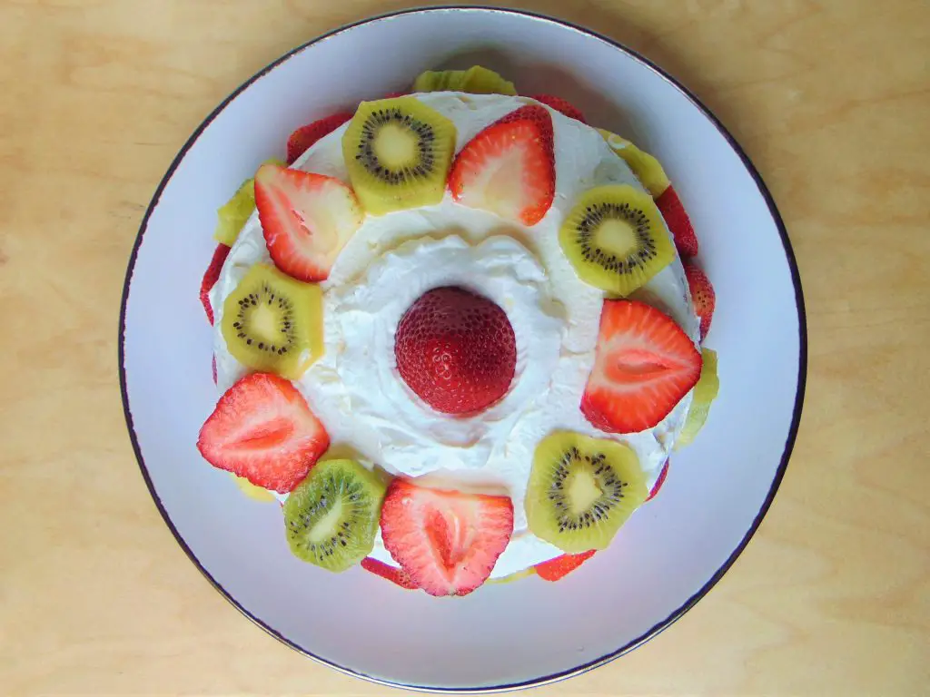 Healthy coconut flour birthday cake with whipped cream and fruit view from above