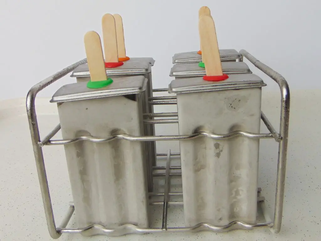 Stainless steel popsicle molds with frozen popsicles