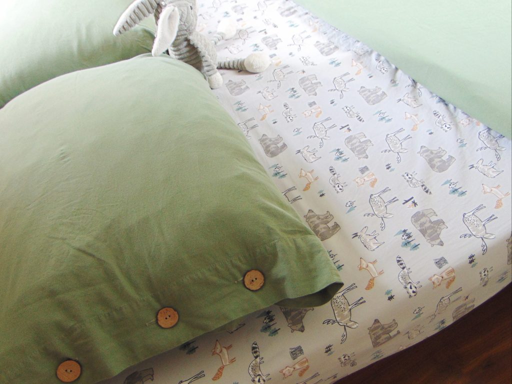 Green duvet cover and woodland theme bed sheet for a minimlist kid's bedroom