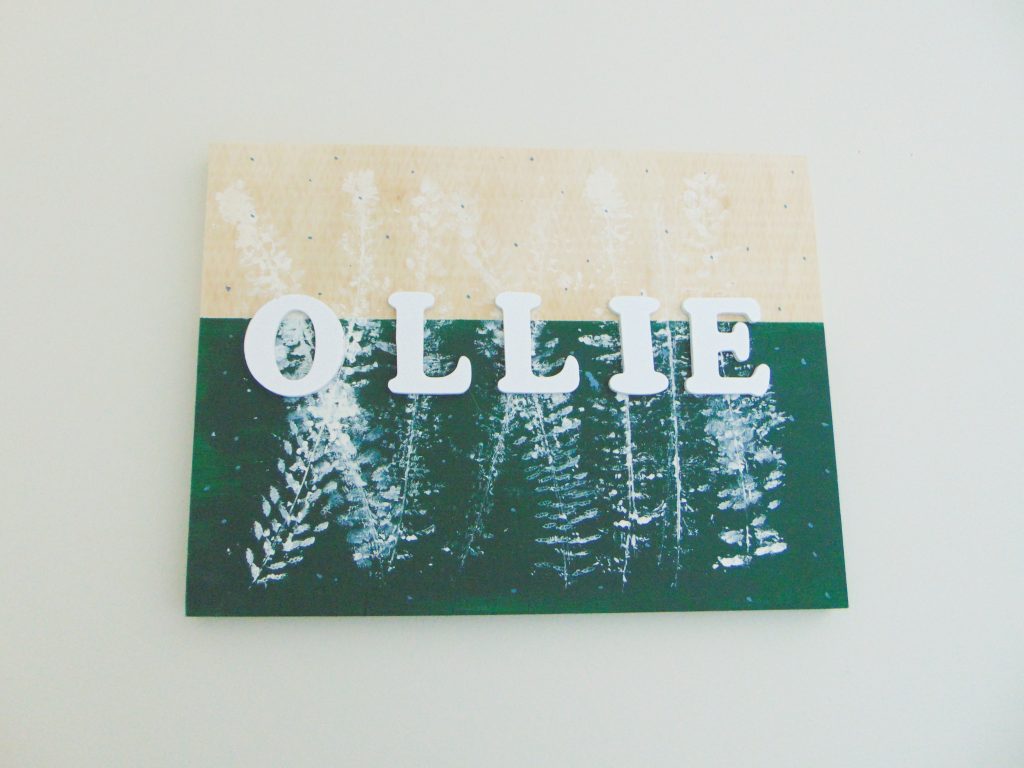 DIY name sign for Ollie used as budget-friendly ecor for a minimalist kid's bedroom