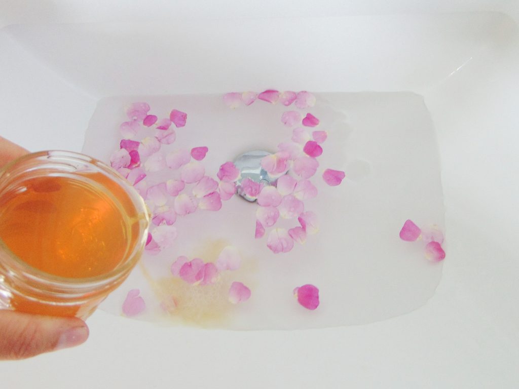 Rose Water made with DIY Recipe added to water an rose petals to show rose water benefits and uses as skincare
