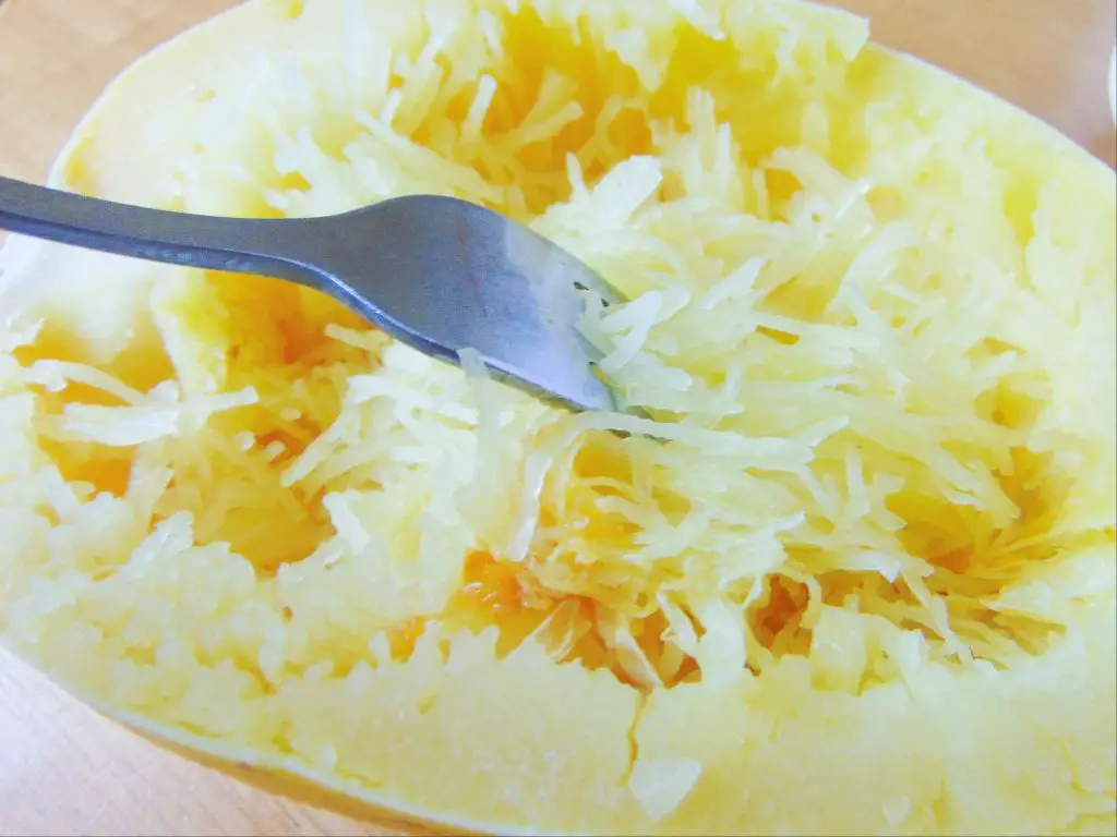 Cooked spaghetti squash being scraped with a fork