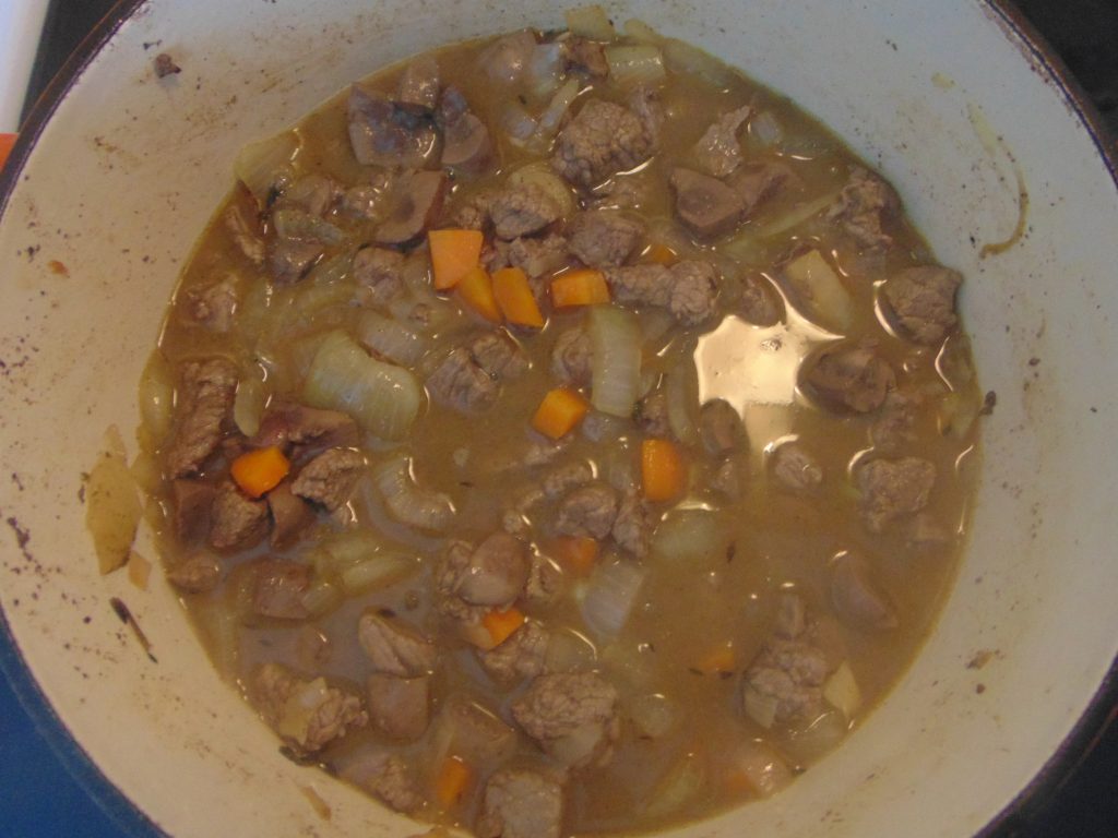 Simmering meat and vegetables in bone broth for making gluten-free Steak and Kidney Pie
