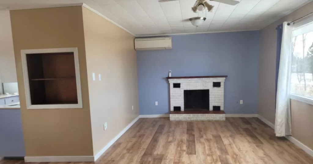 Outdated living room painted blue and brown with old fireplace ready to be transformed into a cozy cottage with a curated Benjamin Moore color palette