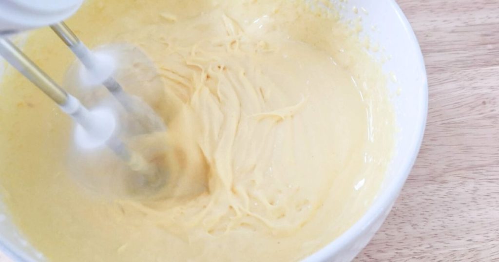 Whisking egg yolks and sugar with electric mixer 