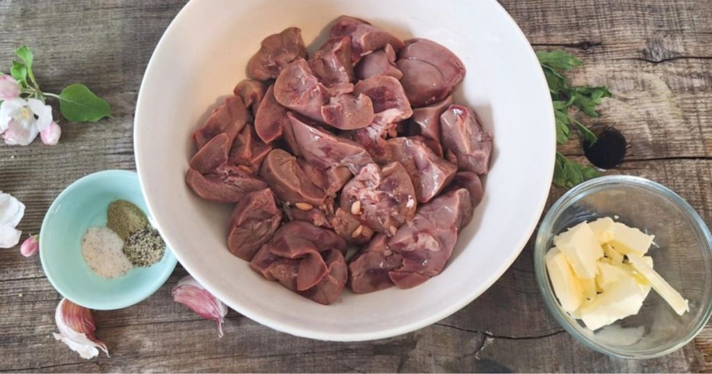 Ingredients for pan-fried beef kidneys displayed on rustic wooden table