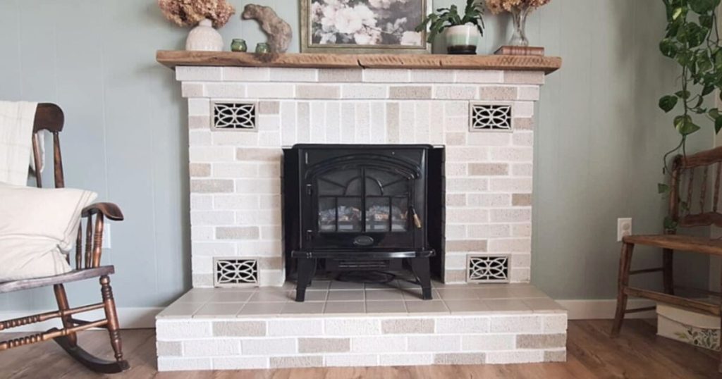 Faux stone DIY painted brick fireplace with distressed wooden mantle and electric fireplace insert